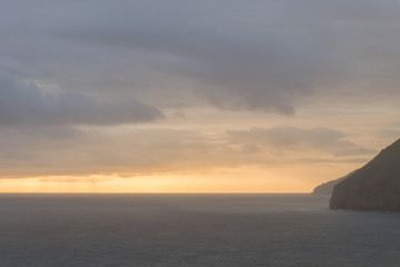 Naklejka na ściany i meble Misty foggy sea landscape image during vibrant sunrise