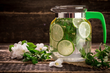 detox water with a lemon, lime and mint on a wooden table