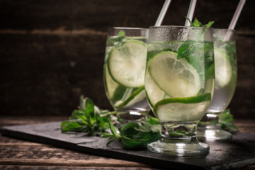 detox water with a lemon, lime and mint on a wooden table