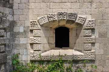Окно на фасаде каменной стены заброшенного форта Мамула в Черногории