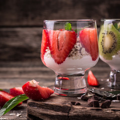 Healthy breakfast or morning snack with chia seeds granola, strawberries and kiwi, vegetarian food, diet and health concept