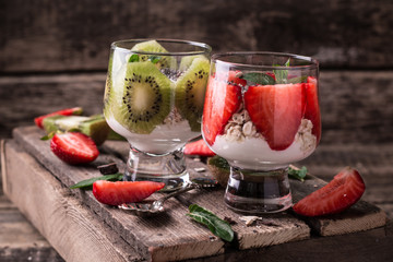 Healthy breakfast or morning snack with chia seeds granola, strawberries and kiwi, vegetarian food, diet and health concept