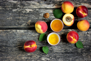 Fresh ripe apricots and apricot oil on old wooden background