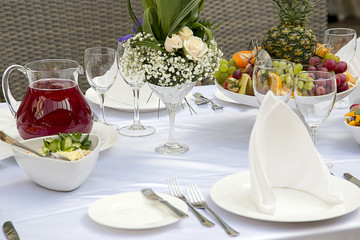Beautifully decorated table in the restaurant. Fresh flowers and fruit.