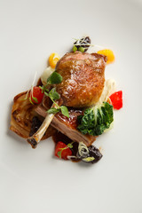 Well-browned and crisp duck confit with roast fennel, citrus fruit and prune sauce. Roasted Duck leg. White dish
