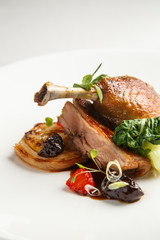 Well-browned and crisp duck confit with roast fennel, citrus fruit and prune sauce. Roasted Duck leg. White dish