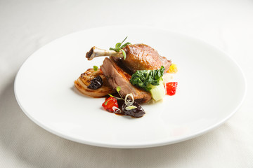 Well-browned and crisp duck confit with roast fennel, citrus fruit and prune sauce. Roasted Duck leg. White dish