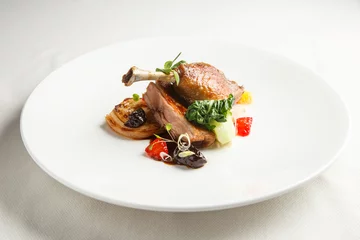Garden poster meal dishes Well-browned and crisp duck confit with roast fennel, citrus fruit and prune sauce. Roasted Duck leg. White dish
