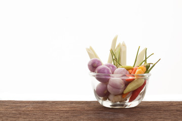 Spices , chilli , shallot , lemongrass in a glass cup on a woode