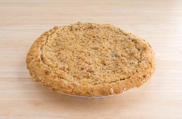 Dutch apple pie on a wood table top illuminated with natural light.