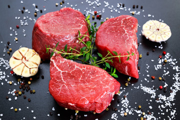 Fresh Raw Beef steak Mignon, with salt, peppercorns, thyme, garlic.