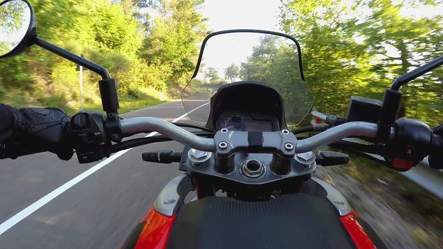 Riding a motorcycle on mountainous road in a sunny day. POV original point of view. Video from action cam and gimbal, steady cam