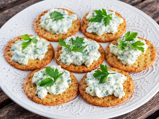 Bisquit cracker appetizers with cottage chees and parsley topping