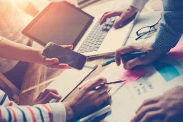 Team meting. Project plan brainstorming. Digital and paperwork. Intentional sun glare and vintage colour