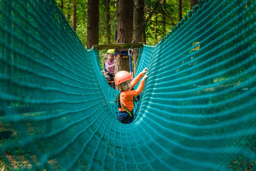 Happy child enjoying in a climbing adventure park