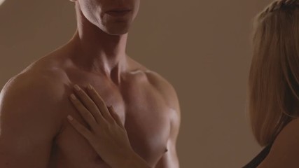 Hands of young woman touching athletic torso with abs of man. Ungraded