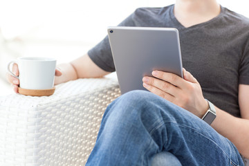 man in summer cafe with smart watch holding tablet computer