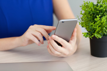 woman in blue dress siting and holding phone