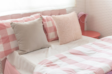pillows on bed in pink color tone bedroom