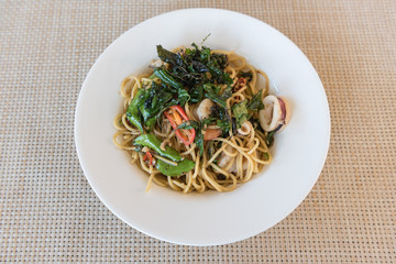 Spicy Spagetti seafood on wood table in restaurant