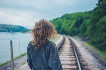 Fototapeta premium Young woman walking on railroad tracks