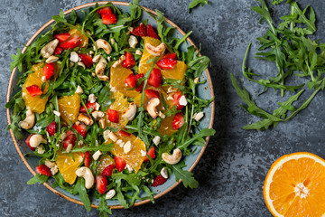 Fresh salad with arugula, fruits and nuts.