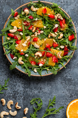 Fresh salad with arugula, fruits and nuts.