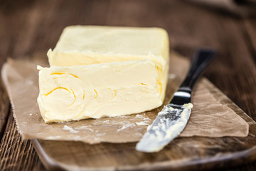 Piece of Butter on wooden background (selective focus)