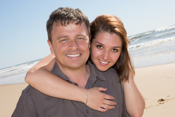 Fototapeta na wymiar Smiling couple in love on the beach flirting