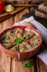 Babaganoush with tomatoes, cucumber and parsley - arabian eggplant dish or salad on wooden background. Selective focus