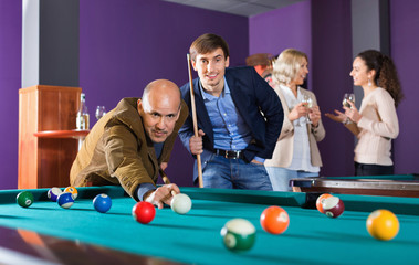 Relaxed  people playing billiard and darts