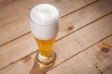 Big glass of beer on wood