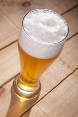 Big glass of beer on wood