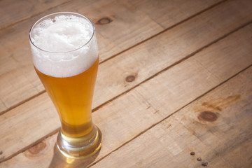 Big glass of beer on wood