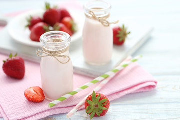 Strawberry yogurt in bottle on wooden table