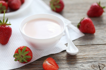 Strawberry yogurt in bowl on wooden table