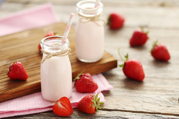 Strawberry yogurt in bottle on wooden table