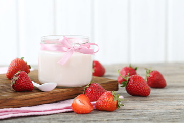 Strawberry yogurt in glass on wooden table
