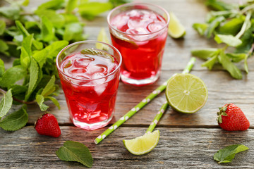 Fresh strawberry drink in glass with lime on wooden table