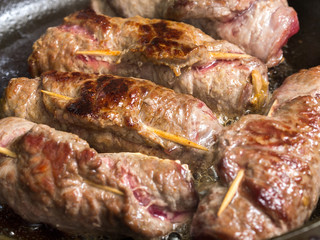 Meat rolls cooking on pan