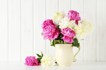 Bouquet of pink and white peony flowers on wal panelling backgro