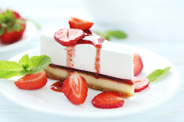 Strawberry cheesecake on plate on blue wooden table