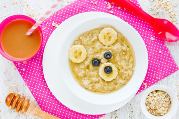 Baby healthy breakfast - oatmeal porridge with honey and banana