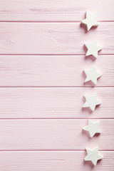 Decorative stars on a pink wooden background