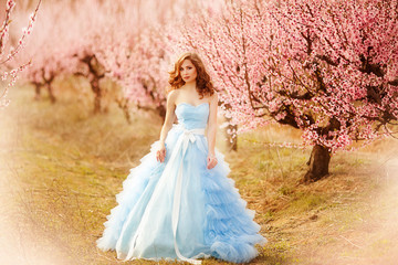 beautiful girl in a blue dress in rose garden