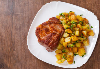 grilled meat fillet steak with fried potato in a plate on wooden table