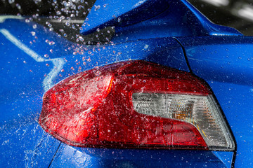 Car detailing series : Water splashing on blue car taillights