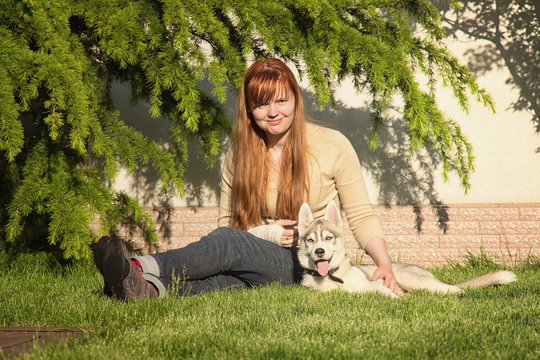 Young woman playing with the dogs. Siberian husky. Puppies.