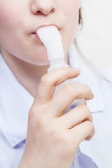 girl inhales with mouthpiece of nebulizer close up