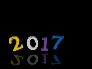 New Year 2017. Bright children's wooden numbers, balanced, on black reflection. Fun.